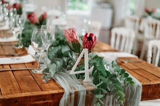 rustic tables with penny gum and protea floral runners
