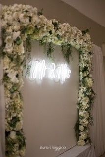 white board with neon light and artificial white flowers with fresh foliage