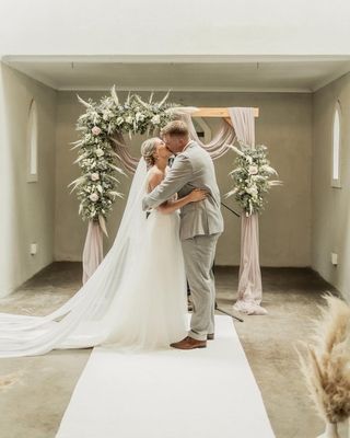soft arch with pampus and flowers and blush drape
